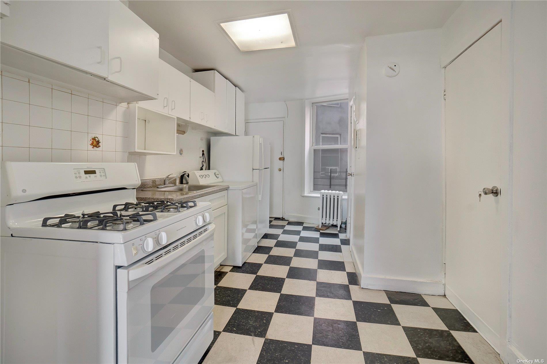 76 Richardson Street, Unit 7 Brooklyn, NY 11211 - Photo 7 of 9 a kitchen with a stove a sink and a black cabinets