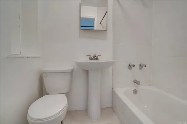 a white toilet sitting next to a bath tub