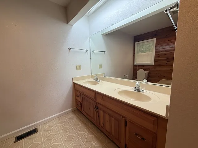 a spacious bathroom with a granite countertop sink toilet and shower