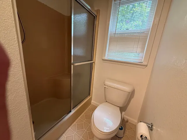 an empty room with windows and fireplace