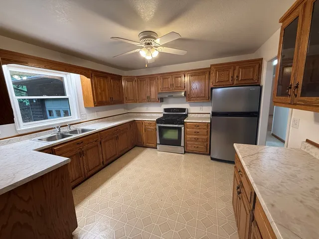 a kitchen with stainless steel appliances granite countertop a sink stove and refrigerator