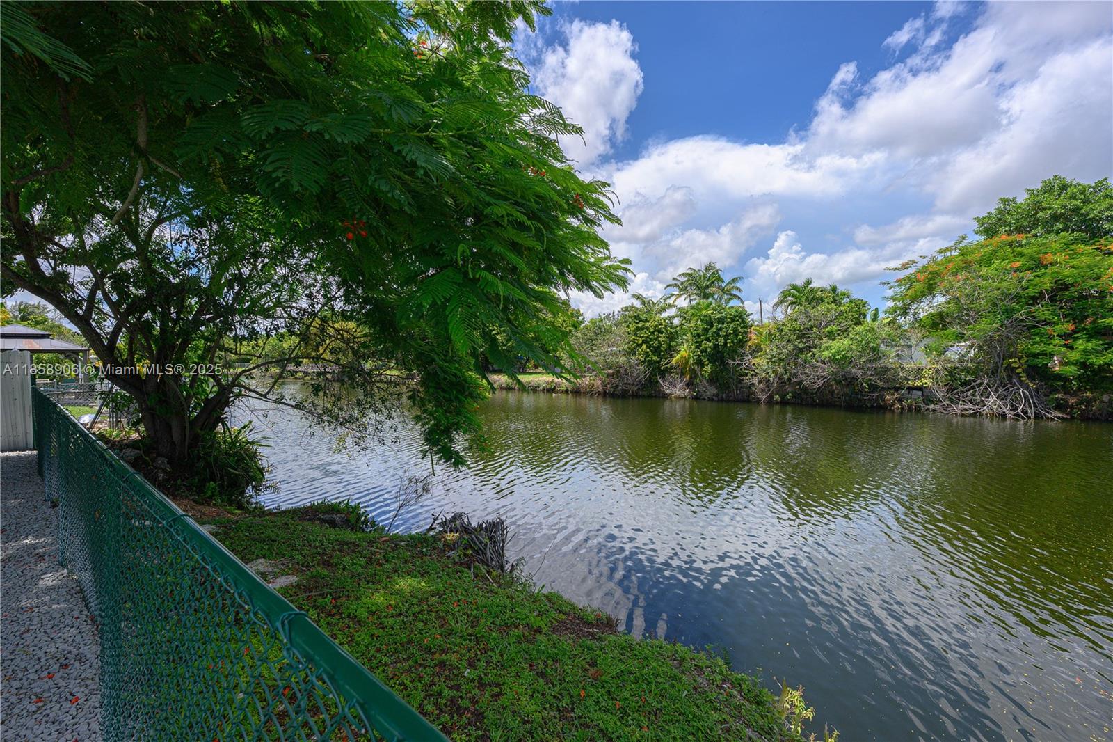 11835 Southwest 37th Street Miami, FL 33175 - Photo 41 of 47 a view of a lake with a yard and large trees