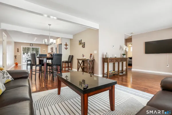 a living room with furniture a flat screen tv and a table