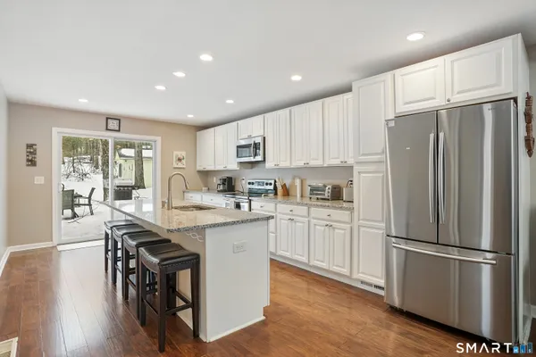 a kitchen with kitchen island white cabinets and stainless steel appliances