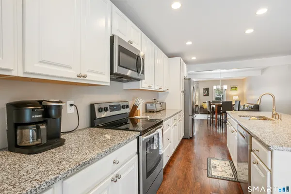 a kitchen with stainless steel appliances granite countertop a stove a sink and a microwave
