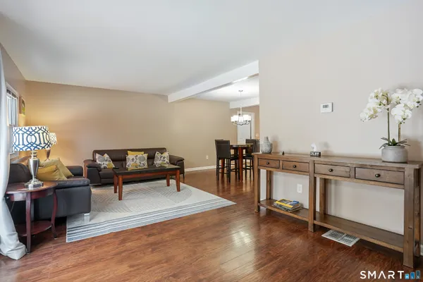 a living room with furniture a dining table and wooden floor