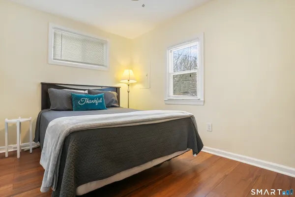 a bedroom with a bed and wooden floor