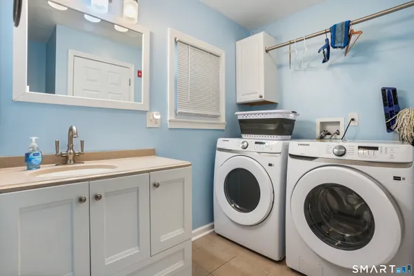 a utility room with sink dryer and washer