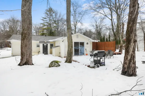a view of a house with snow on the side of the road