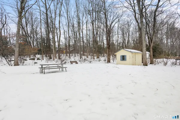 a view of white house with a yard covered in snow