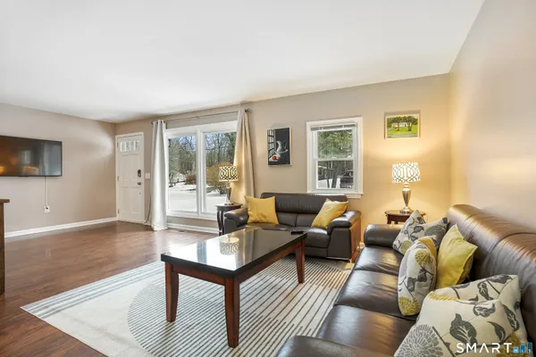 a living room with furniture wooden floor and a flat screen tv