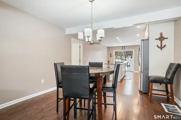 a view of a dining room with furniture a chandelier and wooden floor