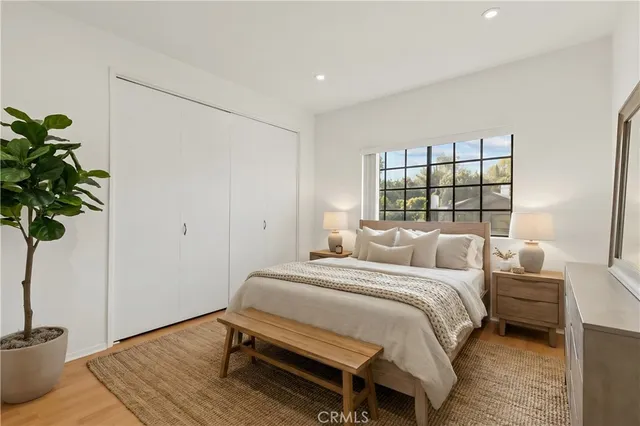 a bedroom with a bed table and a potted plant