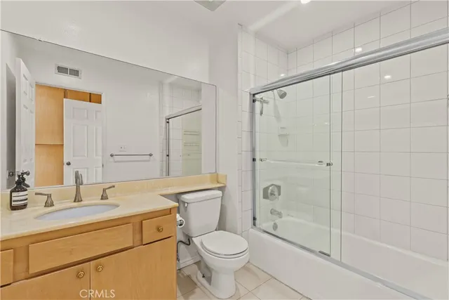 a bathroom with a shower sink vanity mirror and toilet