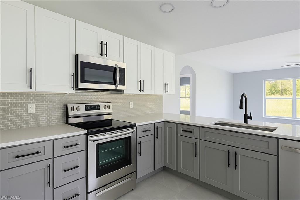 116 Ridgemont Drive Lehigh Acres, FL 33972 - Photo 12 of 45 a kitchen with white cabinets sink and stainless steel appliances