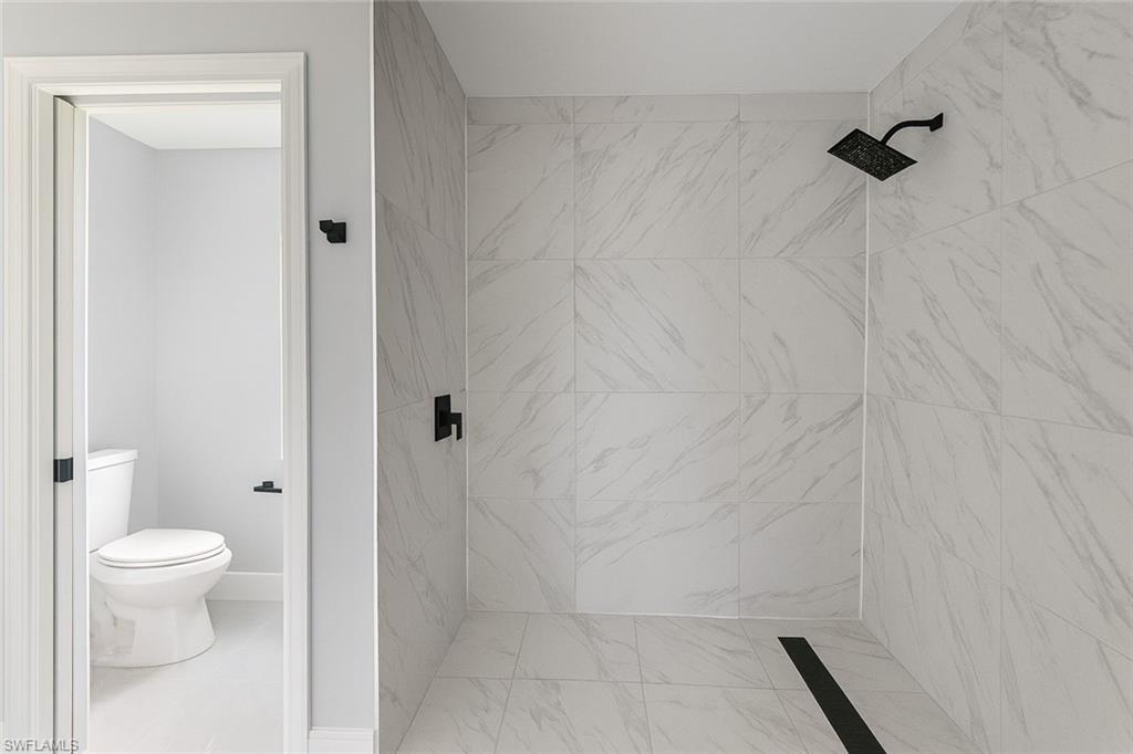 116 Ridgemont Drive Lehigh Acres, FL 33972 - Photo 25 of 45 a bathroom with a granite countertop shower and a toilet