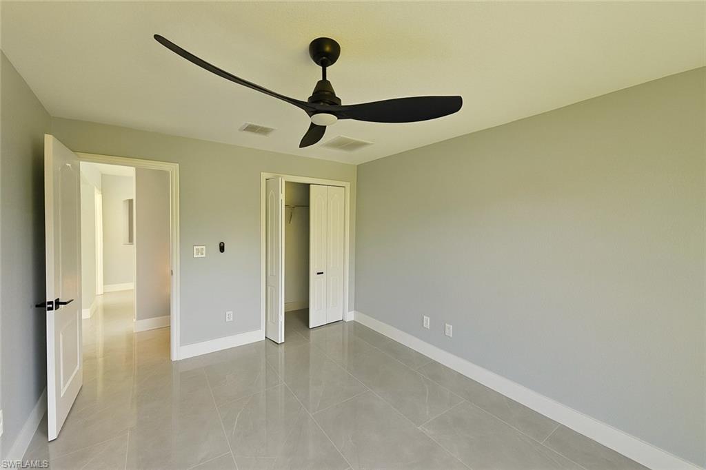 116 Ridgemont Drive Lehigh Acres, FL 33972 - Photo 30 of 45 a view of a hallway with a chandelier fan