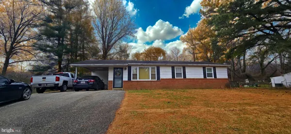 a view of large house with a big yard and large trees