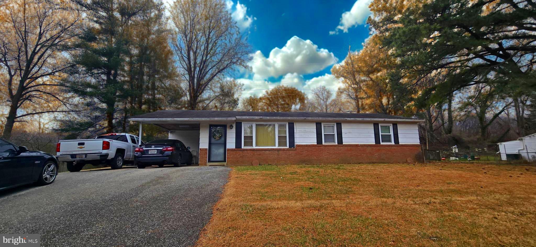 a view of large house with a big yard and large trees