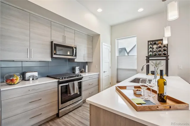 a kitchen with a sink a refrigerator and chairs