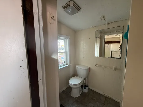 a bathroom with a toilet sink and mirror