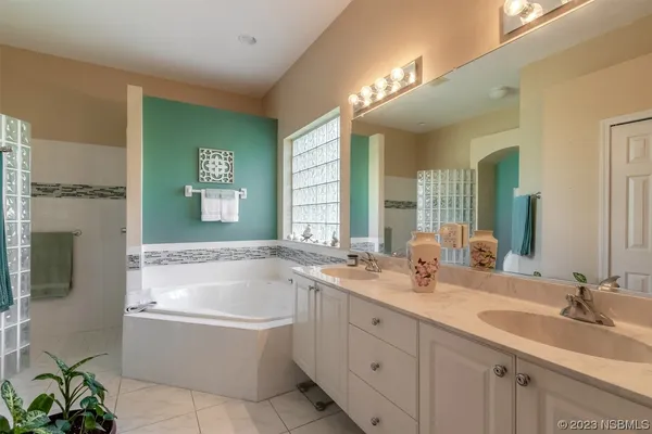 a bathroom with a tub sink and mirror