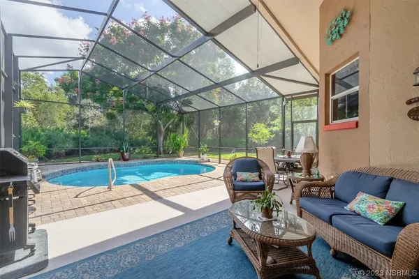 a outdoor space with patio the couches and a dining table with the view of swimming pool