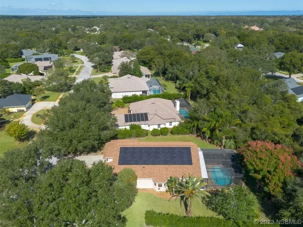 an aerial view of residential houses with outdoor space and trees