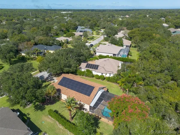 an aerial view of residential houses with outdoor space and trees