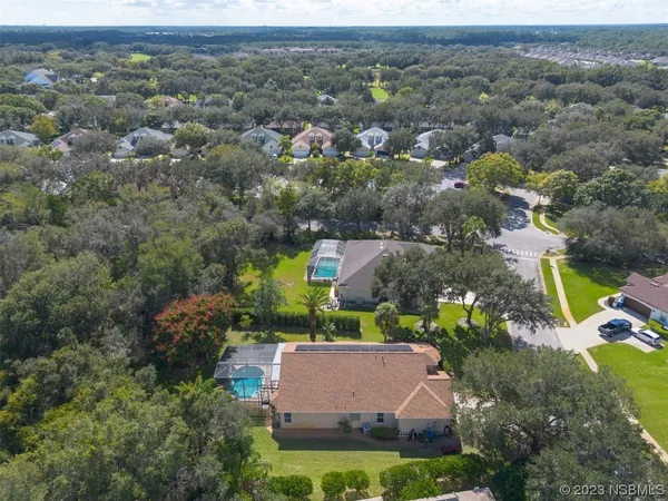 an aerial view of residential houses with outdoor space and swimming pool