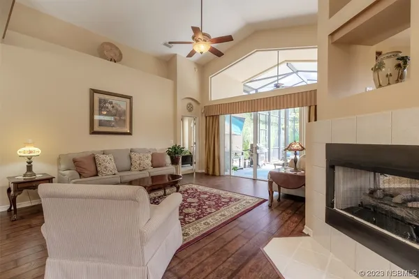 a living room with furniture a fireplace and a chandelier
