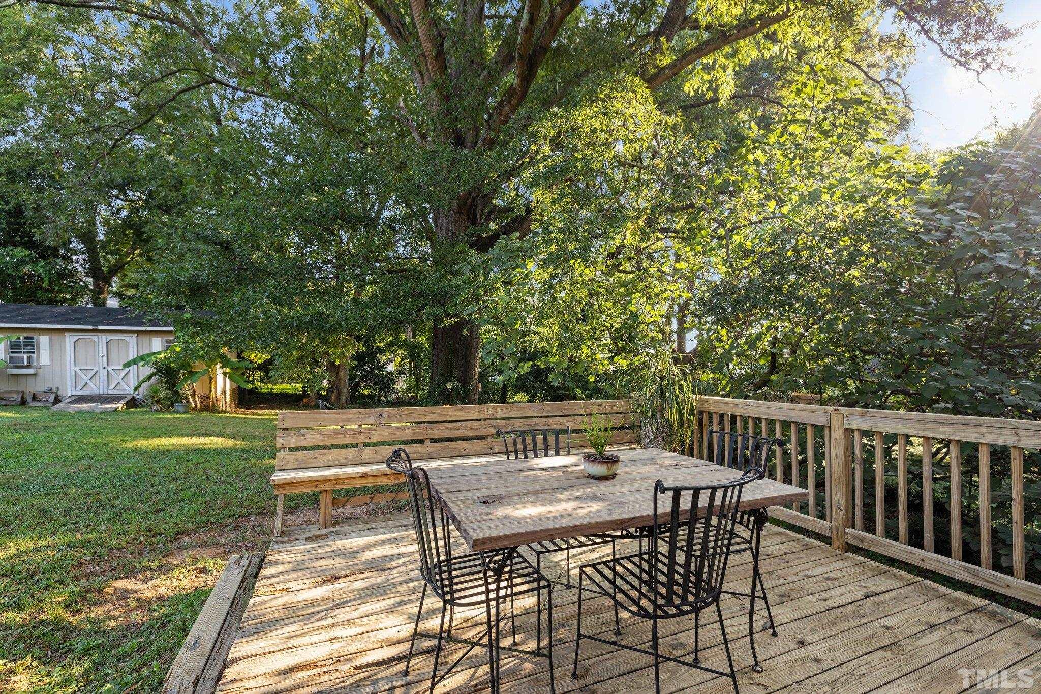 2615 Layden Street Raleigh, NC 27603 - Photo 22 of 34 a view of backyard with a table and chairs and wooden fence