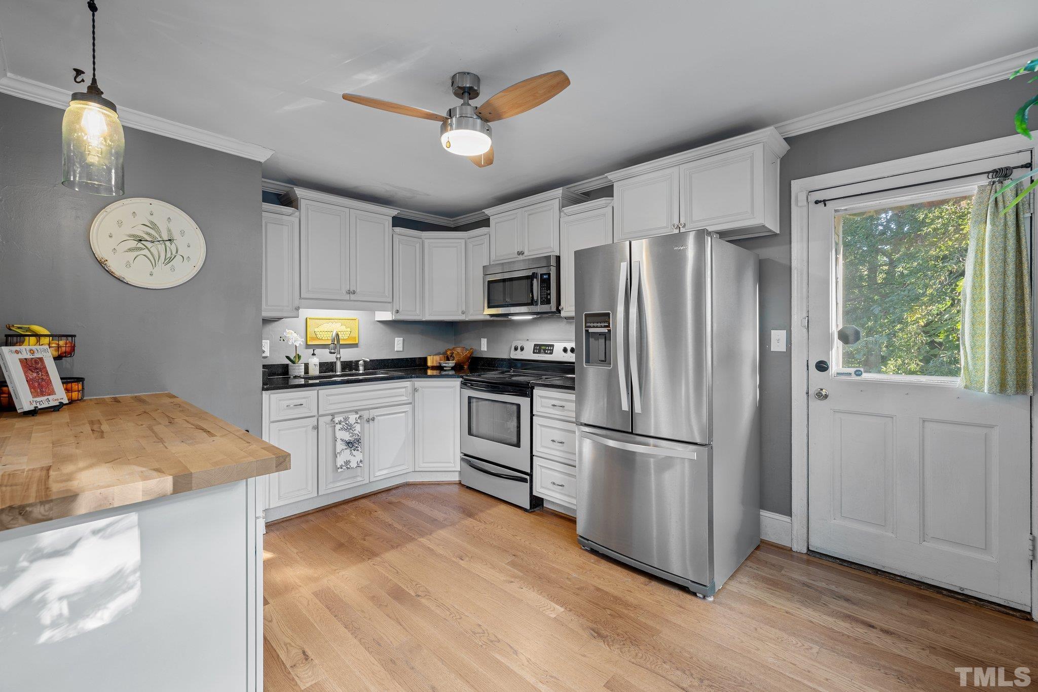 2615 Layden Street Raleigh, NC 27603 - Photo 7 of 34 a kitchen with stainless steel appliances granite countertop a refrigerator a stove a sink and a window