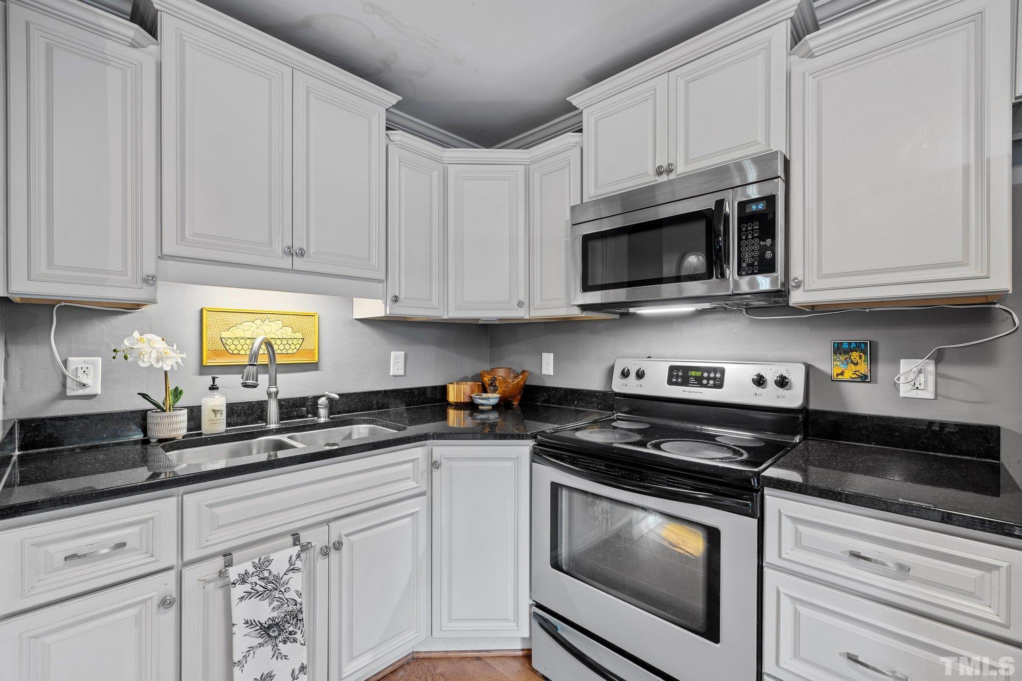 2615 Layden Street Raleigh, NC 27603 - Photo 9 of 34 a kitchen with granite countertop white cabinets and stainless steel appliances
