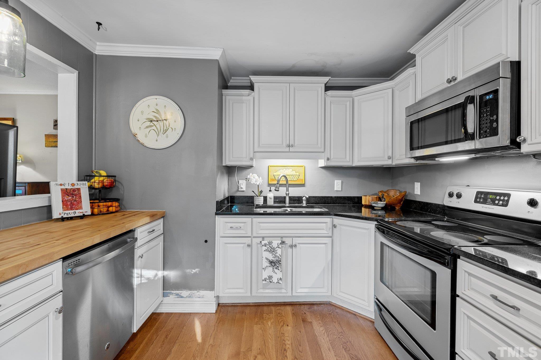 2615 Layden Street Raleigh, NC 27603 - Photo 10 of 34 a kitchen with stainless steel appliances granite countertop a stove a sink and a microwave