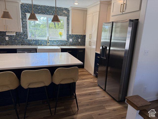 175 North 160 East Hurricane, UT 84737 - Photo 10 of 43 Kitchen with stainless steel appliances, decorative backsplash, dark wood finished floors, pendant lighting, and light stone counters