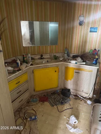 a living room with furniture and three large windows