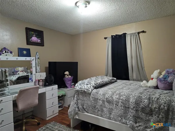 a bedroom with a bed a chair and a fireplace