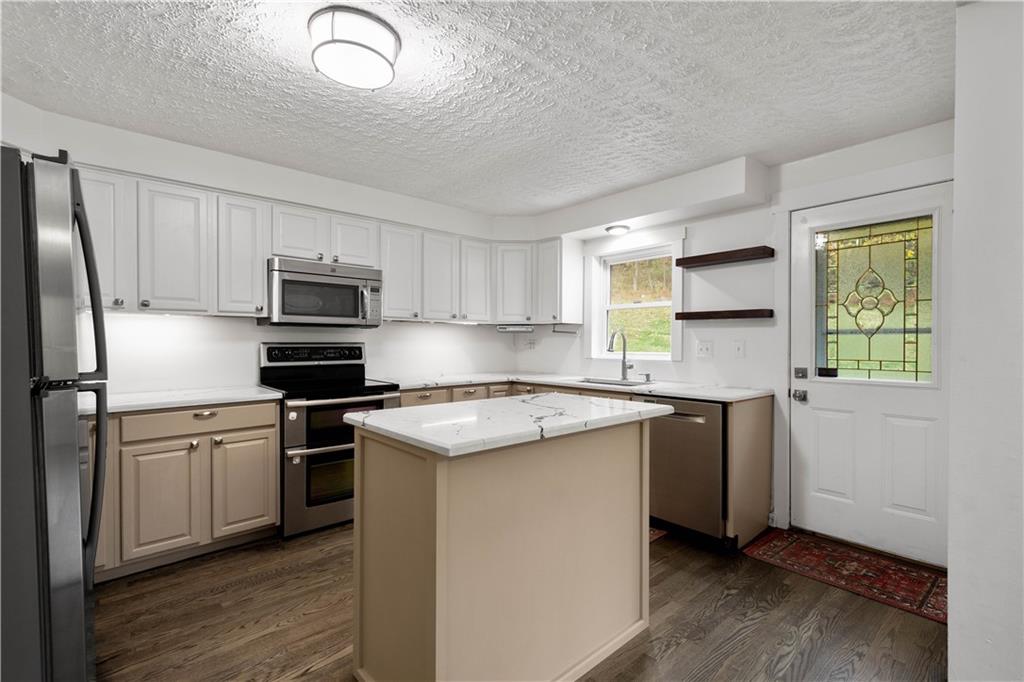 186 Gretna Road Washington, PA 15301 - Photo 7 of 48 a kitchen with stainless steel appliances granite countertop a stove a sink dishwasher a refrigerator and a microwave oven with wooden floor