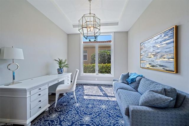 a living room with furniture two window and a chandelier
