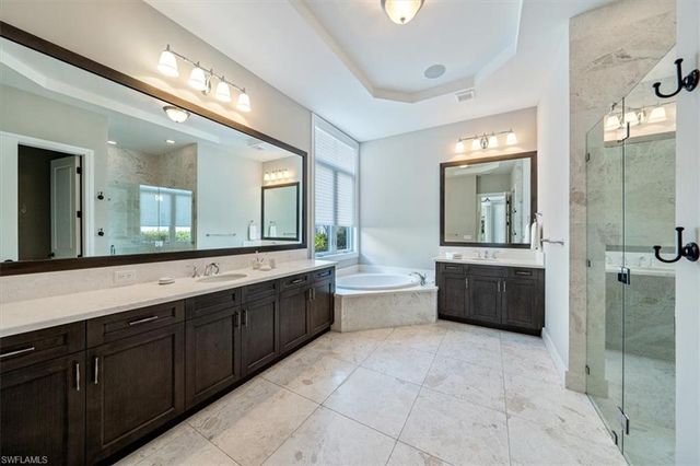 a spacious bathroom with a tub sink shower and mirror