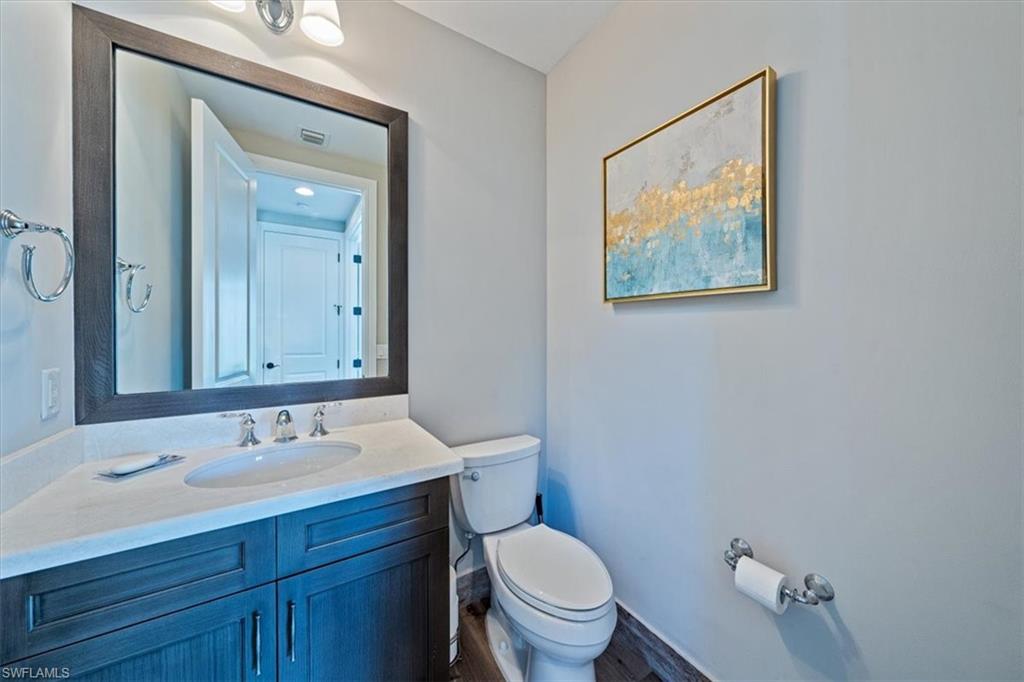 2139 Torino Way Naples, FL 34105 - Photo 19 of 24 a bathroom with a toilet a sink and mirror