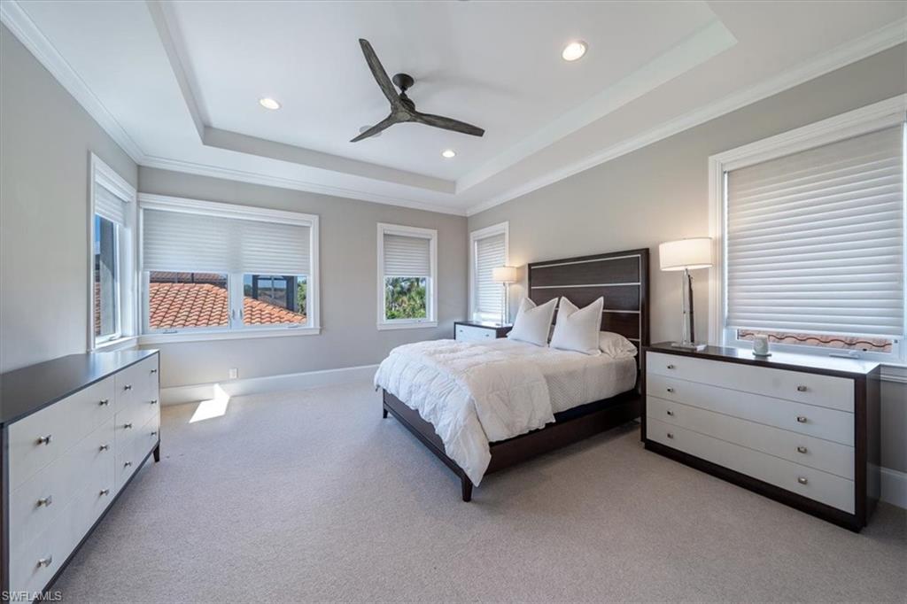 2139 Torino Way Naples, FL 34105 - Photo 21 of 24 a spacious bedroom with a large bed and a chandelier