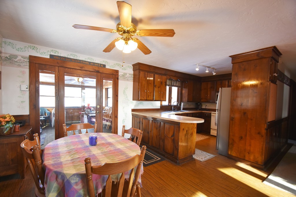46 Davis Road, Unit B Millbury, MA 01527 - Photo 6 of 18 a kitchen with stainless steel appliances kitchen island granite countertop a stove a refrigerator a oven a dining table and chairs with wooden floor
