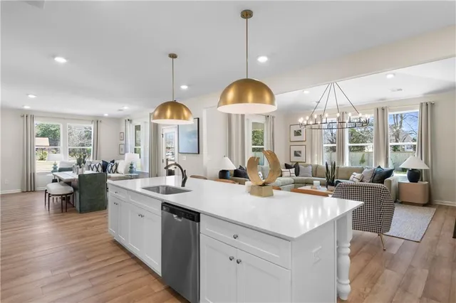 a view of living room kitchen with a sink and chandelier