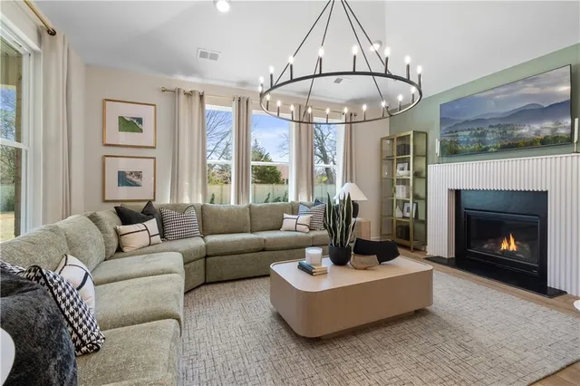 a living room with furniture a fireplace and a large window