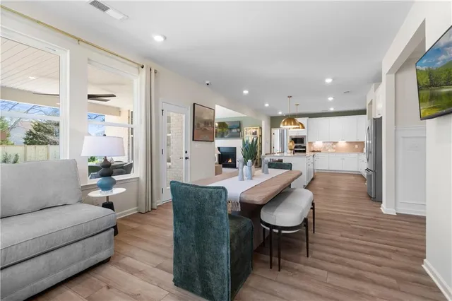 a living room with furniture kitchen view and a large window