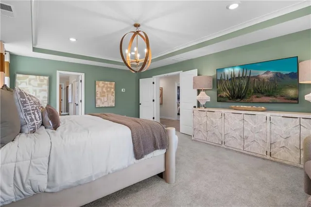 a spacious bedroom with a bed and a large mirror on the dresser