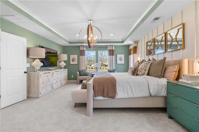 a spacious bedroom with a bed couch chandelier and a window
