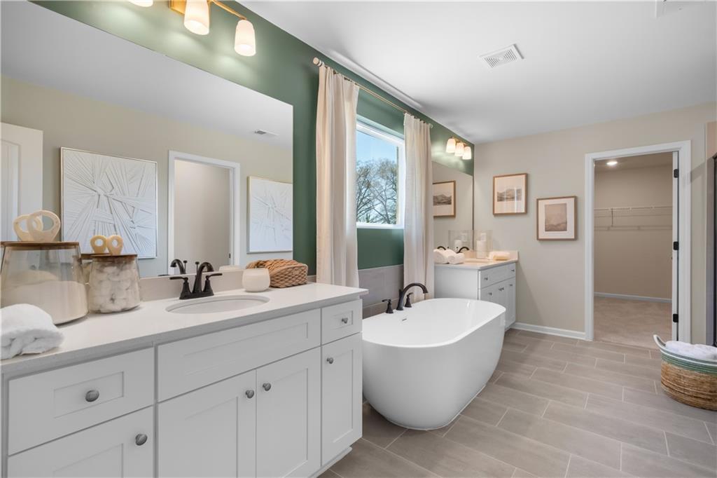 420 Hartsfield Road McDonough, GA 30252 - Photo 41 of 45 a bathroom with a white tub a sink and mirror